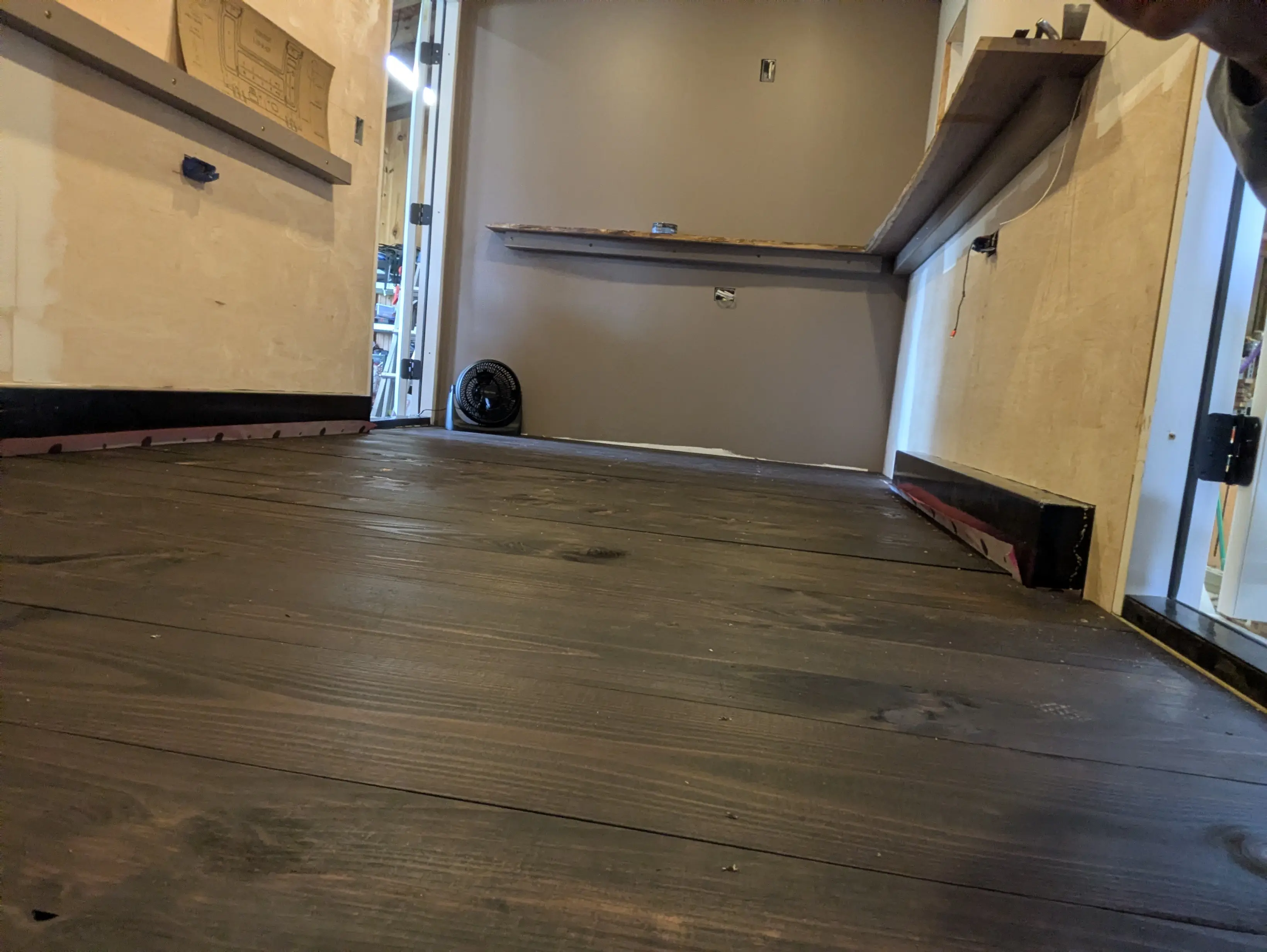 Stained wide plank pine flooring installed inside the Swig Rig