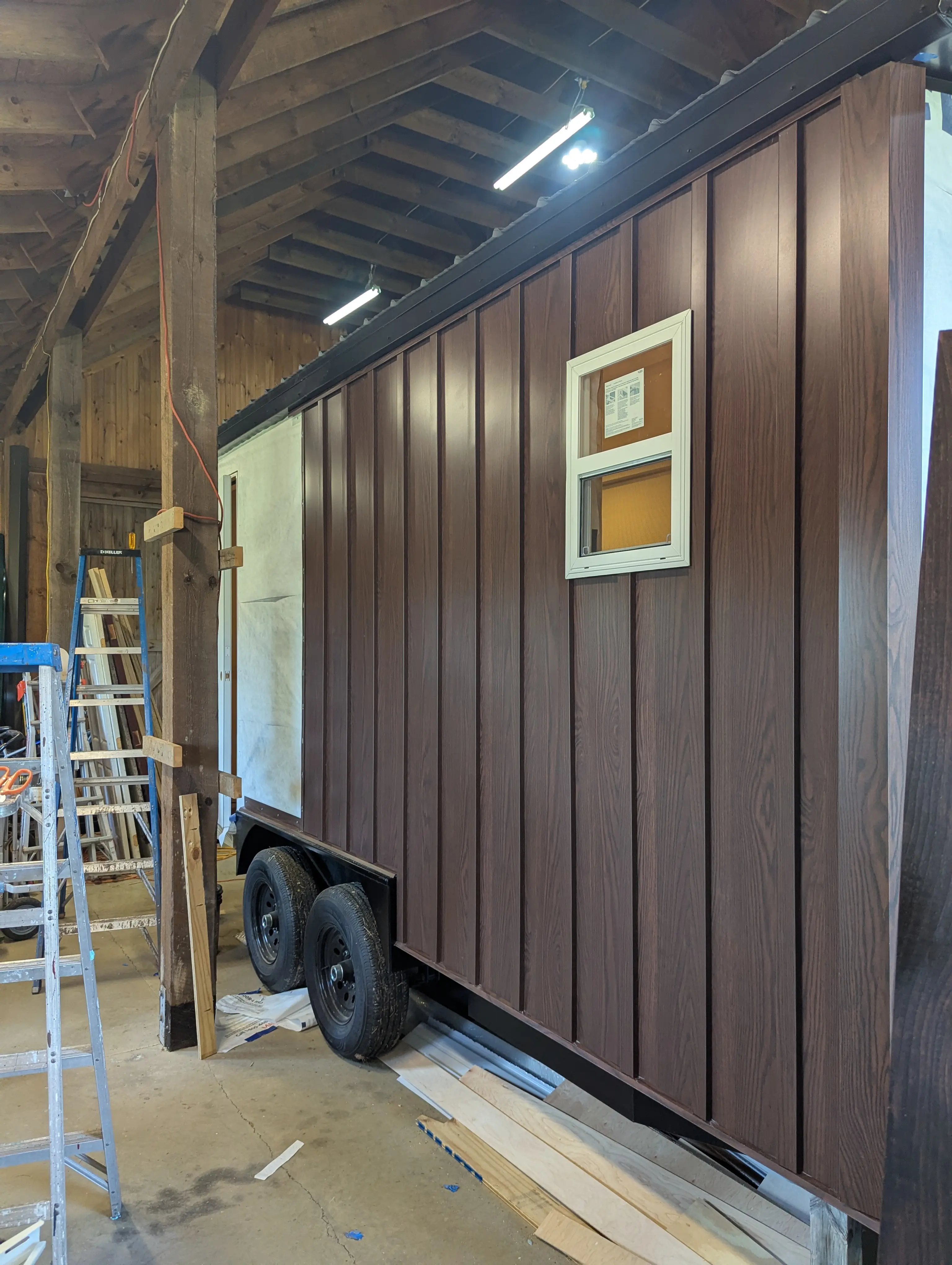 Metal board and batten siding going up on the exterior of the Swig Rig