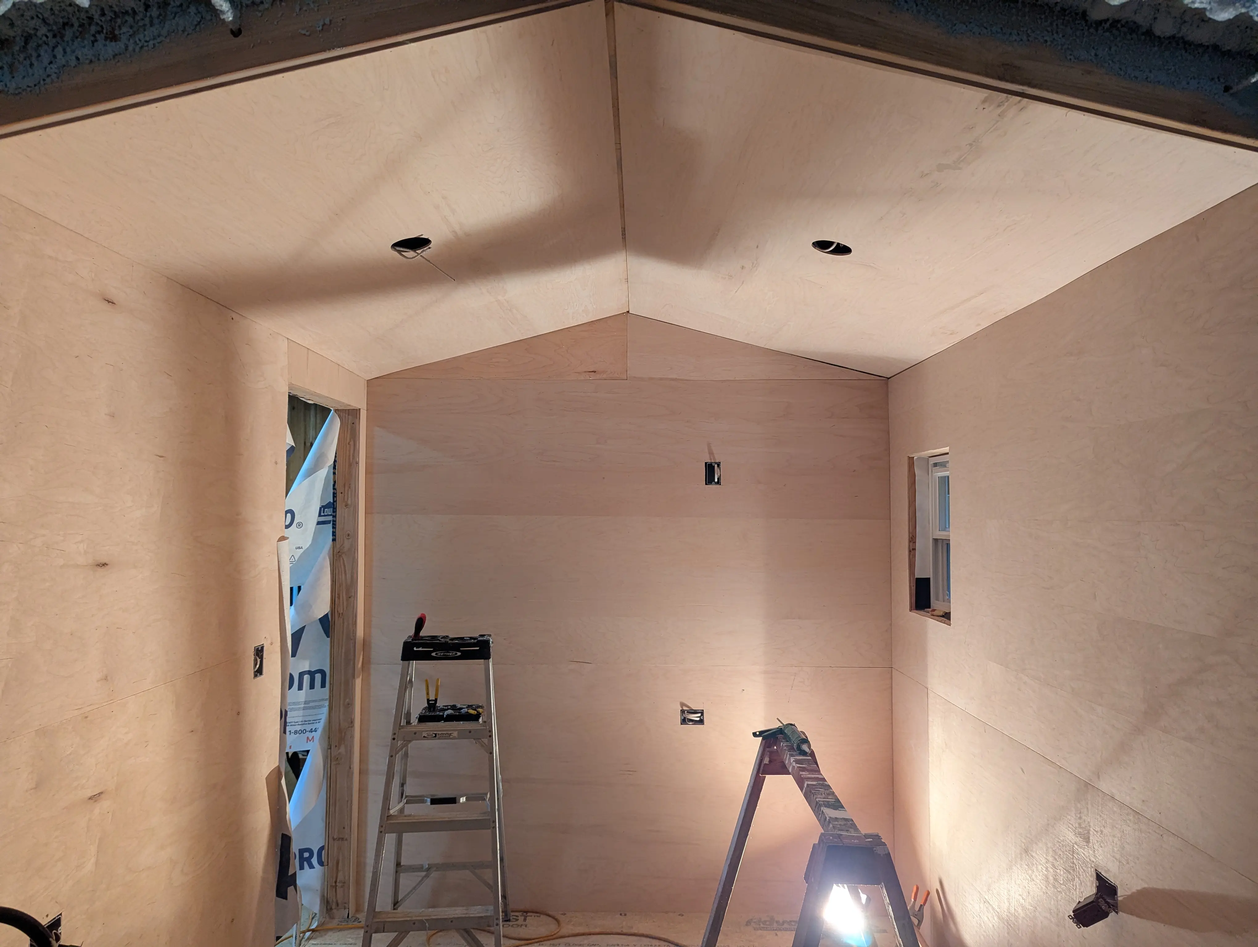 Interior birch plywood panels going up with recessed lighting rough-in
