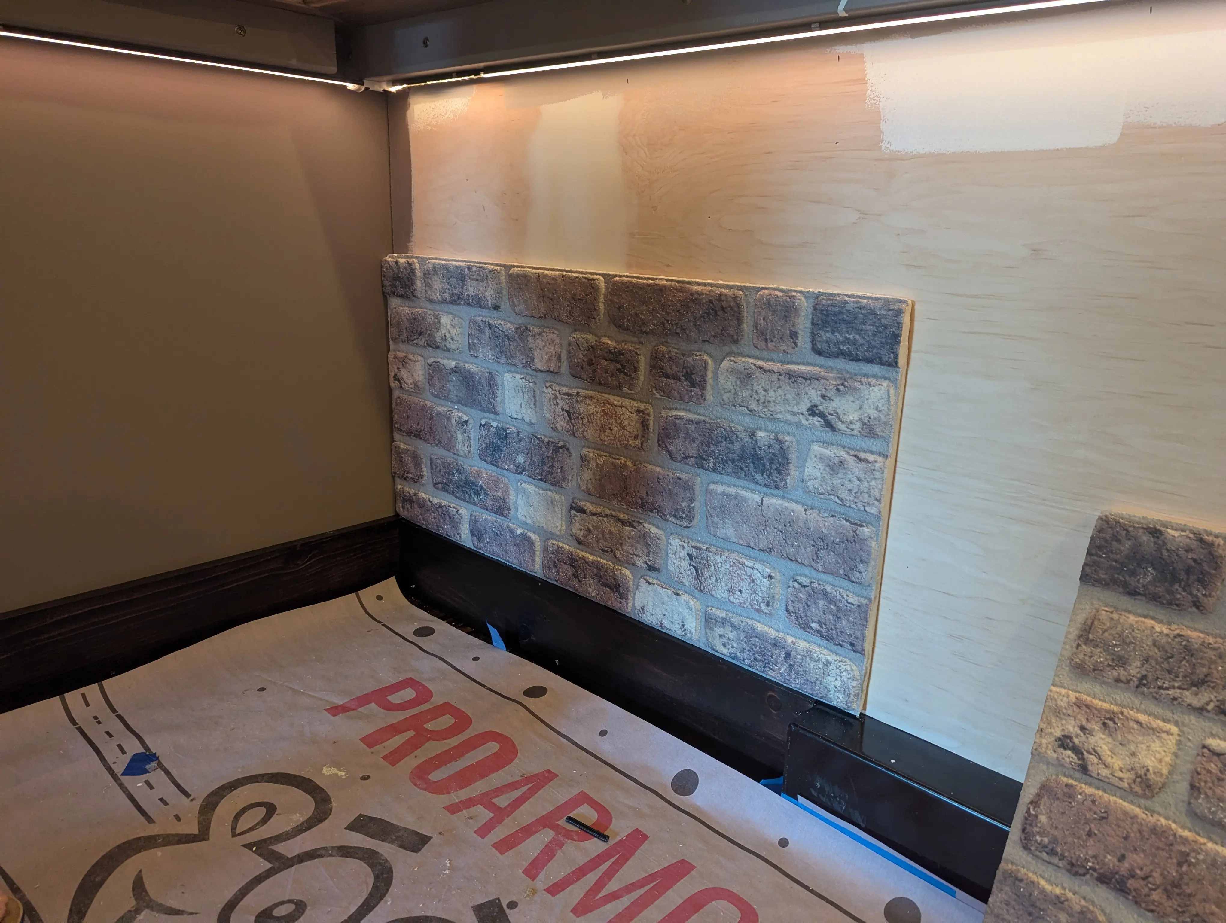 First piece of faux brick going up on the Swig Rig interior wall